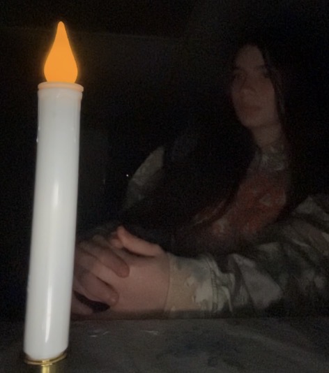 The Outlaw sitting beside a candle
